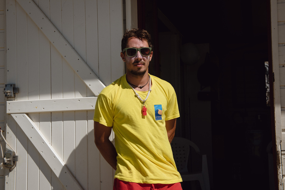 Mahe Vergriette, 22, a lifeguard, stands outside his first aid post on the Pilat beach below the Dune du Pilat, Europe's largest sand dune, near La Taste-de-Buch in the Gironde department of France, during a hot summers day on July 30, 2022. The area had recently seen a dire heatwave, which coincided with terrible wildfires. 