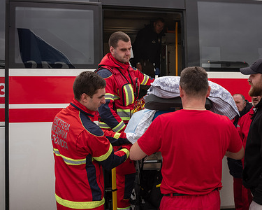 Ukrainian paramedics from  EMS (Emergency Medical Service) transporting severely ill patients from the White Bus to the Norwegian MEDEVAC aircraft, Rzeszów Airport