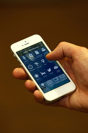 Close up of a person holding an mobile phone using the RC65 application.