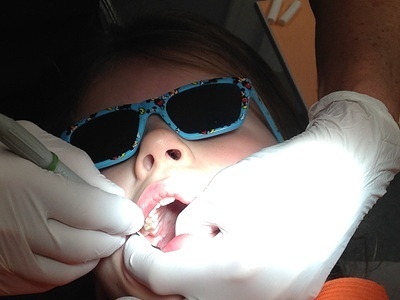 Girl getting her teeth examined by a dentist.